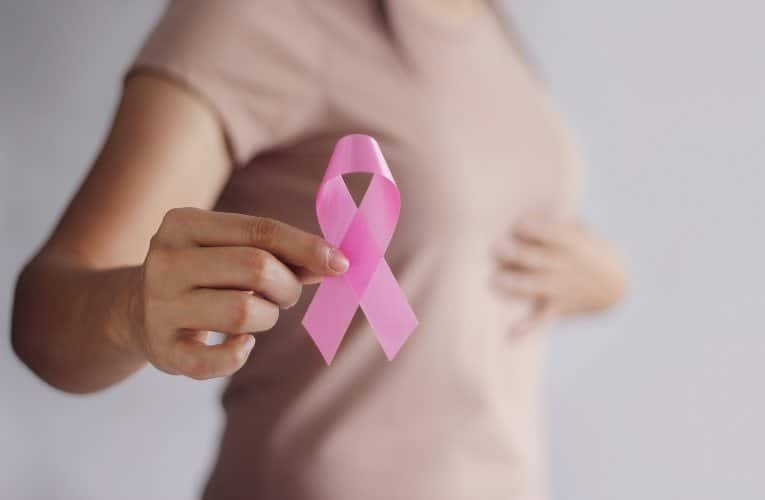 donna che mostra il simbolo della lotta contro il cancro al seno