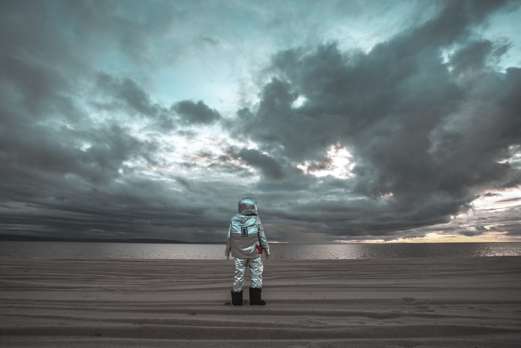 Astronauta solitario che guarda il lago su un pianeta senza nome